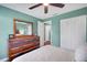 Comfortable bedroom featuring a ceiling fan, closet, and an attractive wood dresser with framed mirror at 4500 Great Lake S Dr, Clearwater, FL 33762