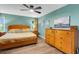 Well-lit bedroom featuring a ceiling fan, matching wood furniture and laminate flooring at 4500 Great Lake S Dr, Clearwater, FL 33762