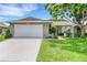 Charming home with a well-manicured lawn, mature tree, and a white garage door at 4500 Great Lake S Dr, Clearwater, FL 33762