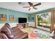 Cozy living room with a large window, leather sofas, and a ceiling fan at 4500 Great Lake S Dr, Clearwater, FL 33762