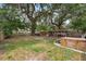 Spacious backyard featuring an above ground pool, hot tub, tiki bar, fire pit, and mature trees at 4522 5Th St, Zephyrhills, FL 33542