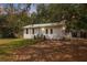 Charming single-story home with a white exterior, black shutters, and a metal roof at 4522 5Th St, Zephyrhills, FL 33542