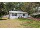 Front exterior of home with black shutters, landscaped yard, and a gravel driveway at 4522 5Th St, Zephyrhills, FL 33542