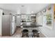 Well-lit kitchen featuring a breakfast bar, white cabinets, and stainless steel refrigerator at 4522 5Th St, Zephyrhills, FL 33542