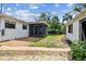 Backyard featuring a screened in lanai, gravel, and a walkway to a detached building at 4560 7Th N Ave, St Petersburg, FL 33713