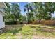 Backyard with green grass, privacy fence, mature trees, and a tall palm tree at 4560 7Th N Ave, St Petersburg, FL 33713