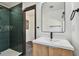 Bathroom featuring wood vanity, black hardware, walk-in shower with green tile and black tiled floor at 4560 7Th N Ave, St Petersburg, FL 33713