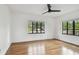 Light-filled bedroom with hardwood floors, a ceiling fan, and two large windows at 4560 7Th N Ave, St Petersburg, FL 33713