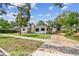 Beautiful home featuring a stone chimney, a gravel driveway, and mature palm trees at 4560 7Th N Ave, St Petersburg, FL 33713