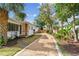 Side view of home showing the gravel driveway, manicured lawn and nearby fence at 4560 7Th N Ave, St Petersburg, FL 33713