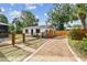 Charming home with a wooden fence and gravel driveway, surrounded by lush greenery and palm trees at 4560 7Th N Ave, St Petersburg, FL 33713