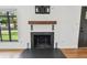 Modern fireplace with a wood mantel, black tile surround, and stylish sconces in a bright living room at 4560 7Th N Ave, St Petersburg, FL 33713
