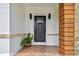 Elegant front entrance featuring a decorative door, brick accents, and a tiled porch with a potted fern at 4560 7Th N Ave, St Petersburg, FL 33713