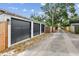 Three-car garage with black doors and lantern-style lighting along a gravel driveway at 4560 7Th N Ave, St Petersburg, FL 33713