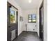 Bright laundry room with black tile flooring, window, washer and dryer hookups and exterior door with doggie door at 4560 7Th N Ave, St Petersburg, FL 33713