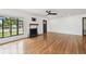Spacious living room with a fireplace, large window, hardwood floors, and a sleek ceiling fan at 4560 7Th N Ave, St Petersburg, FL 33713