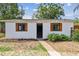 The shed features a white painted brick exterior, wooden shutters, and nicely landscaped flower beds at 4560 7Th N Ave, St Petersburg, FL 33713