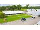 View of complex featuring well-manicured lawns, ample parking, and multiple buildings under a partly cloudy sky at 5251 Flint St, Zephyrhills, FL 33542