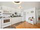 Well-lit kitchen with white appliances, ample cabinet space, and parquet wood flooring at 5251 Flint St, Zephyrhills, FL 33542