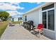 Outdoor patio with grill, lounge chairs and a view of the lush community in this single-story home at 5251 Flint St, Zephyrhills, FL 33542