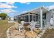 Relaxing patio space with a stone fire pit, chairs, and a screened-in porch for outdoor enjoyment at 5251 Flint St, Zephyrhills, FL 33542