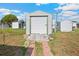 Exterior shot of backyard shed with weathered wood access and concrete block driveway, ample for storage at 5251 Flint St, Zephyrhills, FL 33542