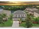 Stunning aerial view of a two-story home with lush greenery and a serene pond backdrop at sunset at 5804 Butterfield St, Riverview, FL 33578