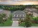 Stunning aerial view of a two-story home with lush greenery and a serene pond backdrop at sunset at 5804 Butterfield St, Riverview, FL 33578