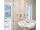 Bright bathroom with modern pedestal sink and direct access door to outdoor pool area at 5804 Butterfield St, Riverview, FL 33578