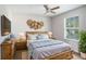 This bedroom includes a wooden bed frame, hardwood floors, and natural lighting at 5804 Butterfield St, Riverview, FL 33578