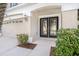 Elegant front entrance featuring decorative glass doors, a covered porch, and well-maintained landscaping at 5804 Butterfield St, Riverview, FL 33578