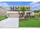 Charming two-story home with well-manicured lawn, mature palm trees, and a two-car garage at 5804 Butterfield St, Riverview, FL 33578