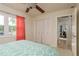 Bright bedroom features a ceiling fan, closet, and view of a manicured lawn at 5823 Dory Way, Tampa, FL 33615