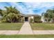 Charming single-story home features mature landscaping, a stone facade, and an inviting walkway to the front door at 5823 Dory Way, Tampa, FL 33615