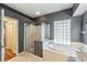 Bathroom area featuring glass block window, walk-in shower, and tiled tub at 6038 Palomaglade Dr, Lithia, FL 33547