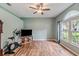 Light-filled bedroom featuring wood floors, a ceiling fan, and a large window at 6038 Palomaglade Dr, Lithia, FL 33547