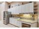 Well-appointed kitchen with white cabinetry, granite counters, and a stainless steel refrigerator at 6038 Palomaglade Dr, Lithia, FL 33547
