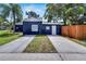 Rear exterior of a blue house with a fenced-in yard and long driveway at 6110 N Suwanee Ave, Tampa, FL 33604