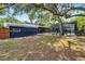 Backyard view showcasing the home's screened in pool, expansive yard and lush, mature landscaping at 6110 N Suwanee Ave, Tampa, FL 33604