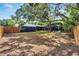 Spacious backyard with a screened in pool area, mature trees, and partial fencing at 6110 N Suwanee Ave, Tampa, FL 33604