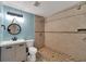 Updated bathroom featuring a tiled shower and modern vanity with a round mirror at 6110 N Suwanee Ave, Tampa, FL 33604
