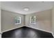 Bedroom featuring modern ceiling light, two windows, and black wooden floors at 6110 N Suwanee Ave, Tampa, FL 33604