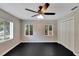 Bright bedroom with a ceiling fan, three windows, and black wooden floors at 6110 N Suwanee Ave, Tampa, FL 33604