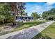 Beautifully landscaped lawn leads to the quaint blue and white home with covered porch and manicured garden beds at 6110 N Suwanee Ave, Tampa, FL 33604