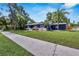 Stylish blue house with a green lawn and sidewalk in a tranquil neighborhood setting at 6110 N Suwanee Ave, Tampa, FL 33604