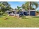 Beautifully updated home with fresh exterior paint, lush lawn, and charming front porch with white picket fence at 6110 N Suwanee Ave, Tampa, FL 33604