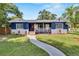 Charming blue two-story home featuring a welcoming front porch and well-maintained lawn at 6110 N Suwanee Ave, Tampa, FL 33604