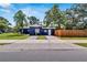 Charming home featuring a well-manicured lawn, driveway, and inviting facade with updated exterior paint at 6110 N Suwanee Ave, Tampa, FL 33604