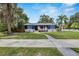 Inviting two-story blue house with a charming front porch and lovely green lawn at 6110 N Suwanee Ave, Tampa, FL 33604