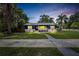 Charming updated exterior paint on a beautiful home with manicured lawn, sidewalk and picturesque landscaping at 6110 N Suwanee Ave, Tampa, FL 33604